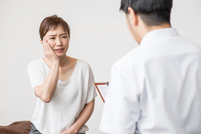 歯のトラブルを訴える女性