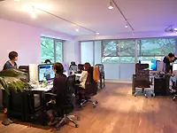 黒と木目が基調のゆとりあるレイアウト。間接照明により、オフィスはさらにモダンかつ落ち着いた雰囲気に