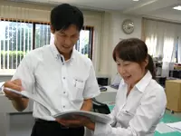 地図や資料を見ながら訪問の相談。親身に応えてくれるから未経験スタートでも安心！
