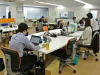 清潔感のある広々としたオフィスでは、社員同士が顔を見合わせながら仕事をしています