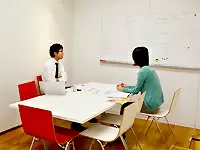 オフィスの一角にはシンプルなミーティングルーム。赤いイスがオシャレなアクセントに。