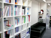 たくさんの参考書籍で埋まった本棚と、リフレッシュスペース。コーヒーもご自由に！