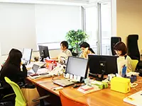 大きい窓と、明るい木目調のデスクが印象的なオフィス。開放的な雰囲気で、のびのび勤務★