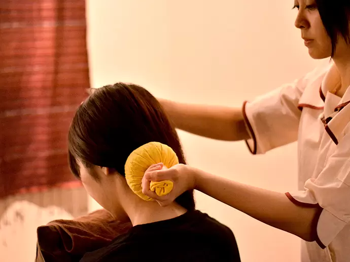 何種類ものハーブを布で包み、温めたものでコリをほぐす手技。タイの伝統医療から生まれた技です。