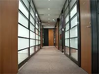 木とガラスの質感を活かした会議室がずらりと並ぶオフィス