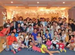 今年度の社員旅行、グアムでの集合写真。社員の子どももこっそり写りこんでいます。
