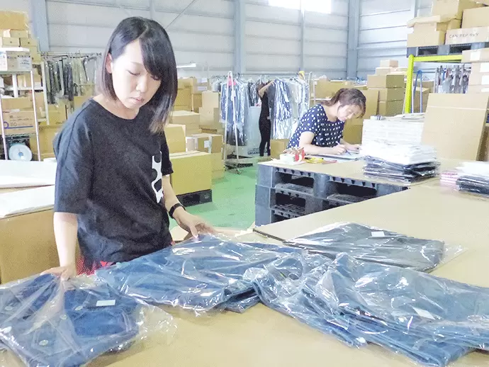 倉庫スタッフの作業風景。幅広いアパレル商品を扱っています。