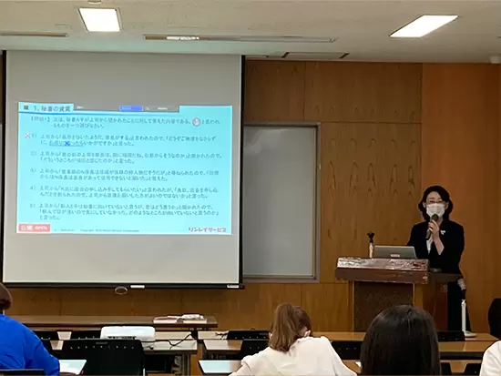 募集中の「研修講師」写真／教壇に立ちマナー指導をしている様子です！