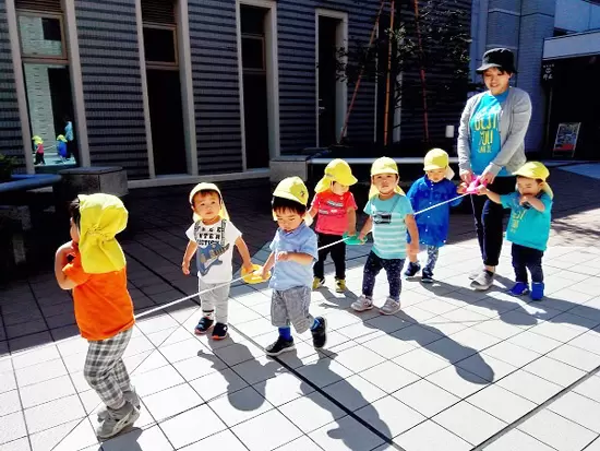 幼児さんたちと楽しくお散歩。複数名のスタッフで安全面に気を配ります。