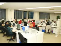 白を基調としたインテリアに赤いイスが差し色になっているおしゃれな品川本社。