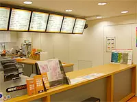 オレンジ&黒が基調の明るい店内。来店の方向けカウンターです。