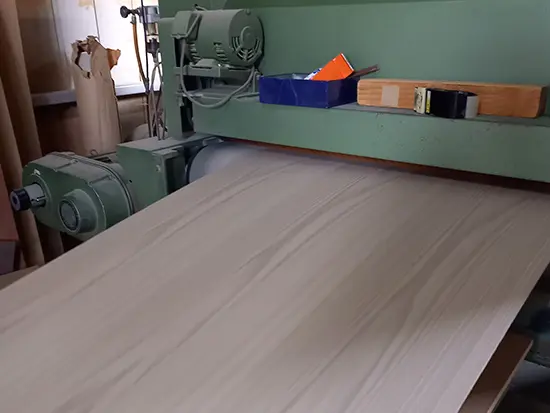 貼り合わせた板を巨大な研磨機（ベルトサンダー）に通し、表面全体を完全に滑らかに美しく仕上げます。