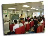 【会場】黒板でプレゼン中。お子様からご老人まで来られます。