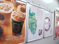 日差しが差し込むオフィス。季節限定のコーヒーのポスターは、私たちの努力の証です