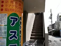 会社は中野駅から徒歩8分。季節感あふれる並木通りを進むとこの看板が見えてきます