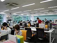 白を基調にしたオフィスに、鮮やかなオレンジ色のイスが並べられています。