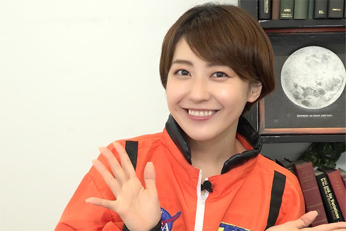 オレンジスーツを着てほほえむ黒田有彩さん