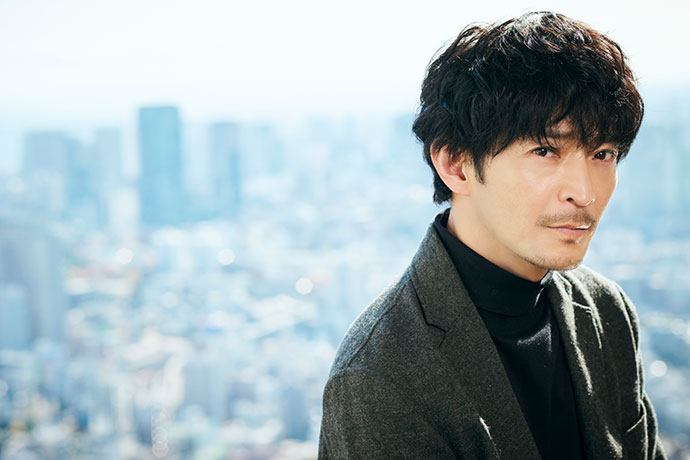 カメラに向かってポーズを取る津田健次郎さん