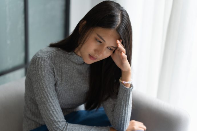 悩んでいる女性の写真