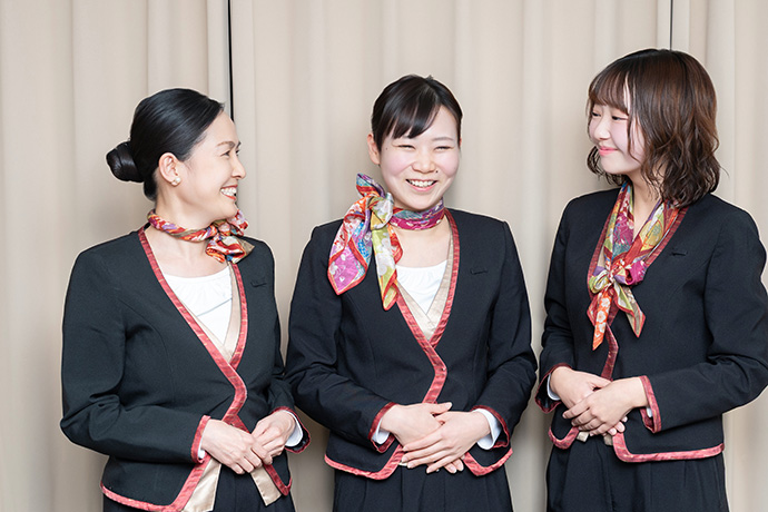 談笑する京阪電車のプレミアムカー車内アテンダントの女性たち