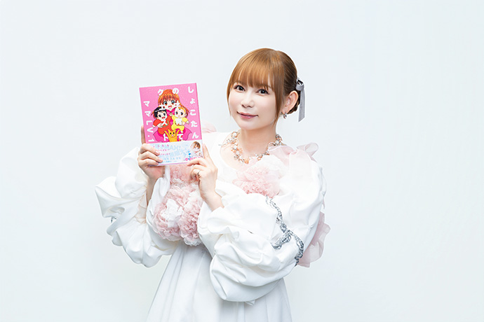 『しょこたんの子育てクエスト　ママLV.1』（宝島社）を手に取り微笑む中川翔子さん