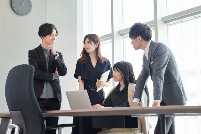 職場で自ら提案する女性の写真